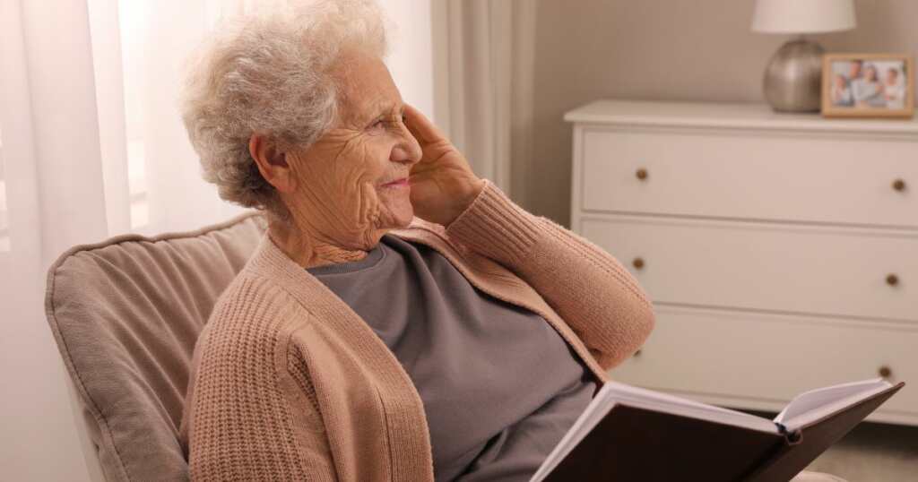 Elderly woman with Alzheimer - touching her head