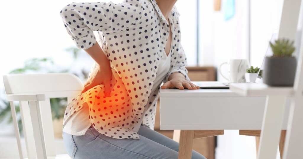 Woman - muscle spams - low back - blur office background