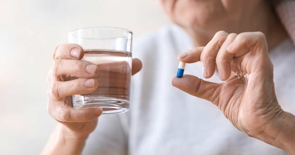 Woman taking pills - Cannabis treatment for IBD - science treatment