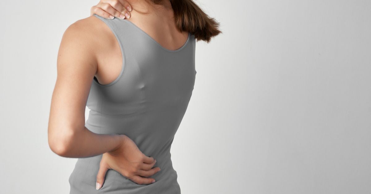 Woman with muscle spasm in the shoulder and back