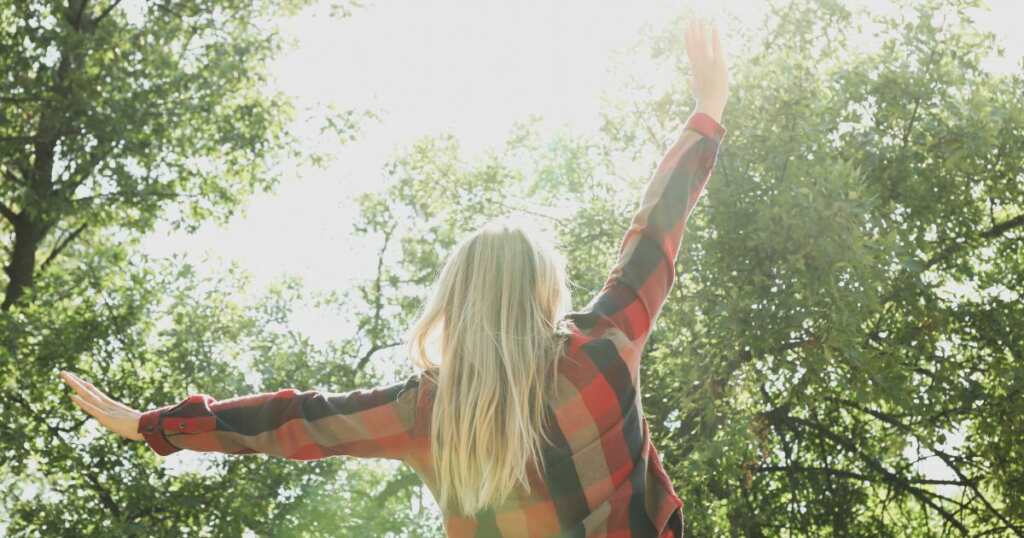 Woman with social anxiety relief - after crisis - nature -open arms