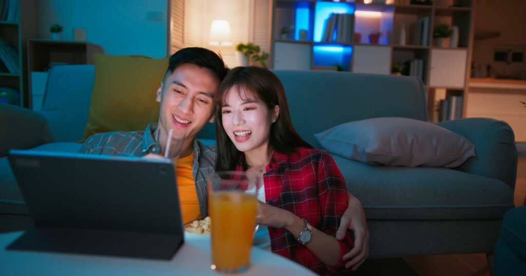Couple of young people watching a movie - smiling - having an elevated experience