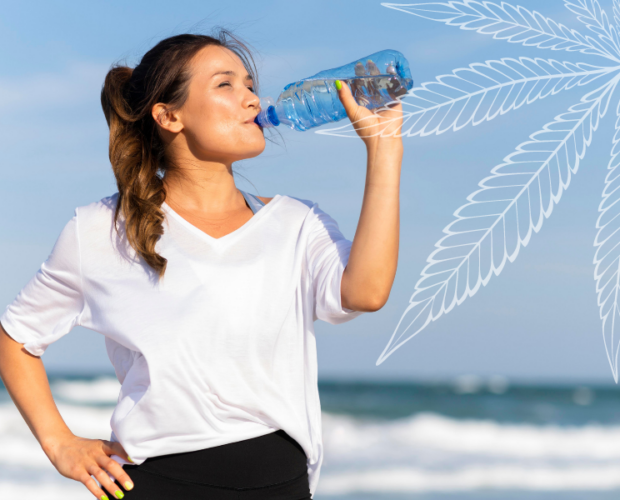 This image features a woman drinking water after working out high.