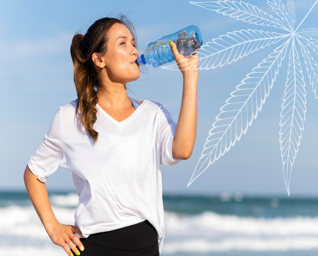 This image features a woman drinking water after working out high.