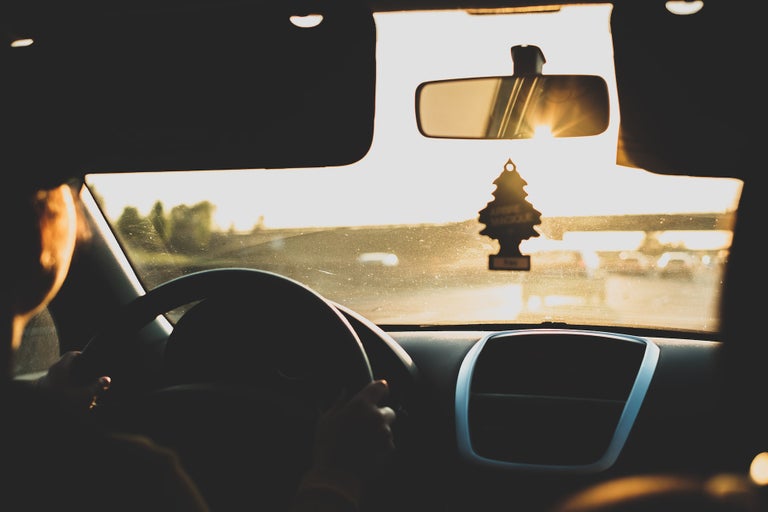 Driving car in setting sun