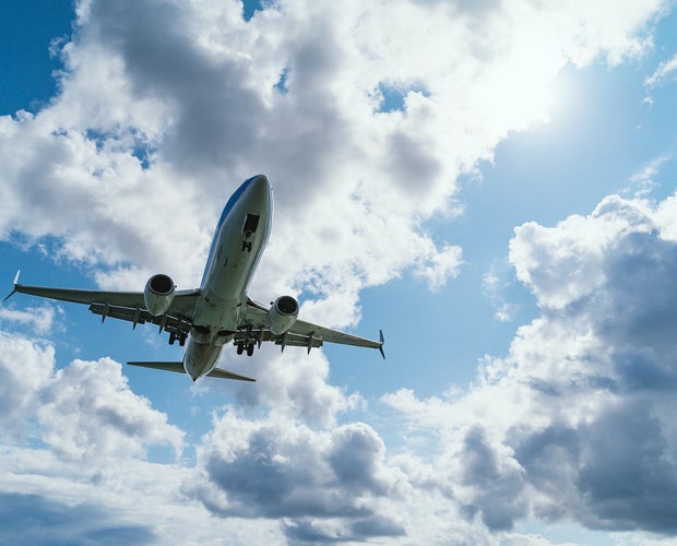 A domestic airplane flight in Canada . Plane is flying through blue skies and clouds.