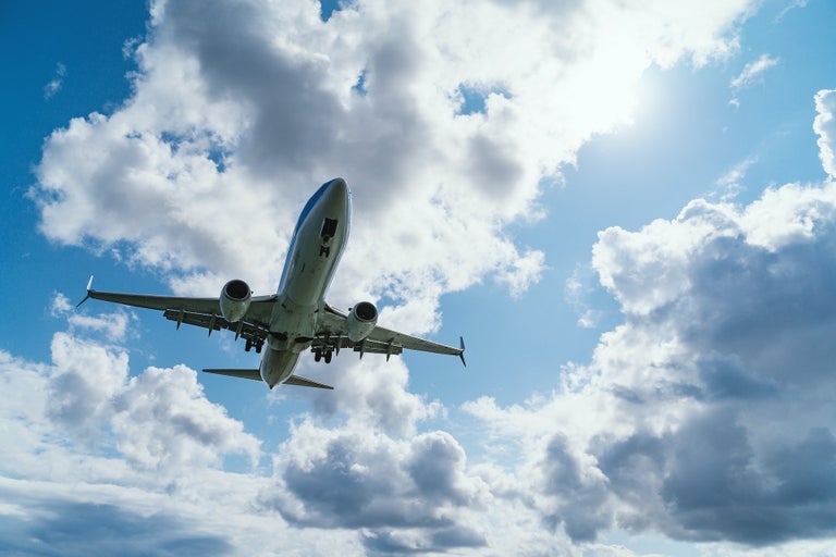 A domestic airplane flight in Canada . Plane is flying through blue skies and clouds.