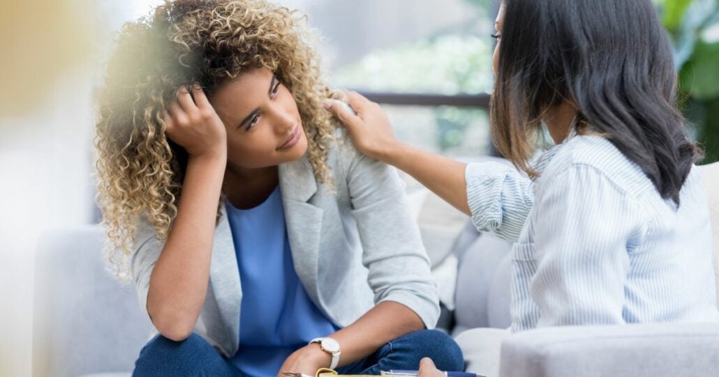 Young curly haired woman seeking advice from a counsellor.