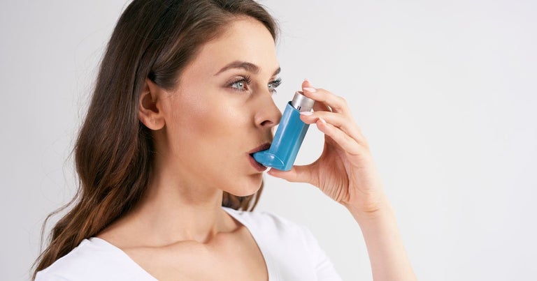 Woman with asthma. She is holding an epi pen to her mouth.