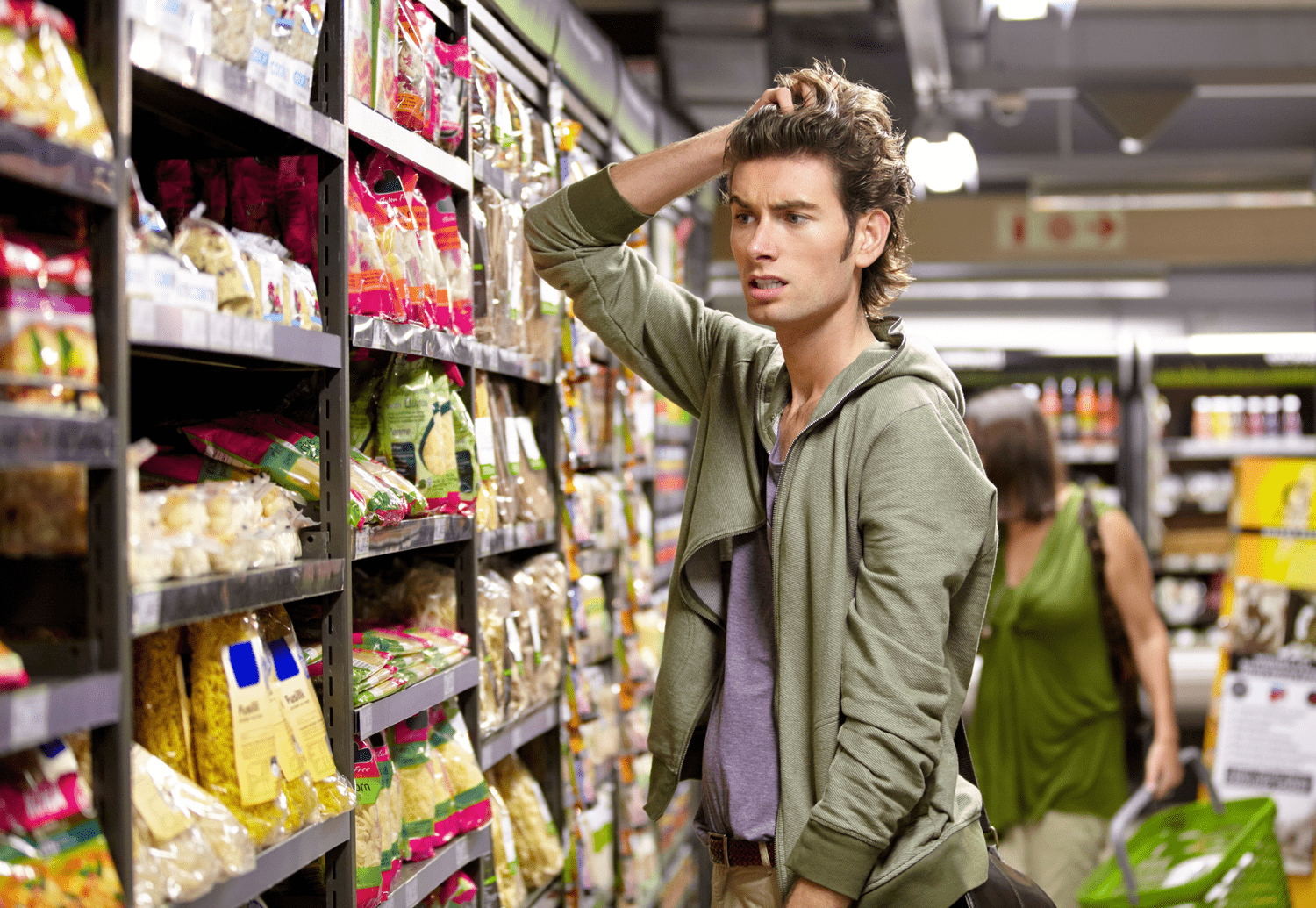Confused young man at the grocery store choosing products