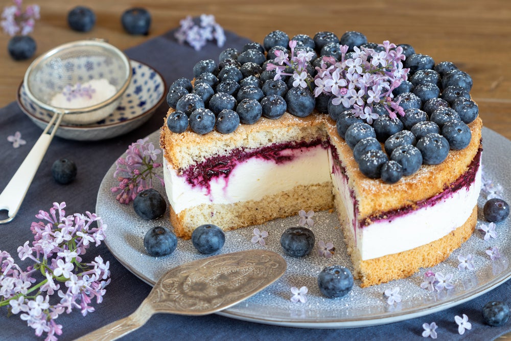 Blueberry Cake With slice removed and dining utensils