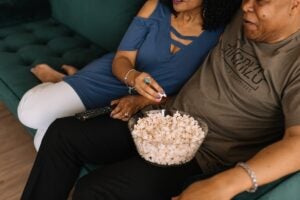 Couple watching a movie while eating popcorn.
