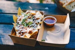 A picture of Mexican delivery food on a blue bench.