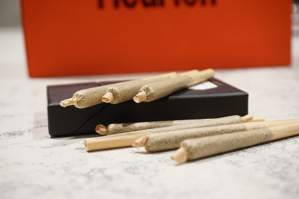 7 professionally rolled joints laid on on a white table.