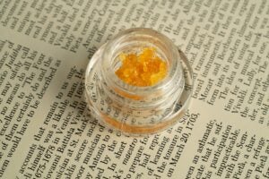 packaged live resin. Orange bubbly substance is contained in a circular and plastic case.