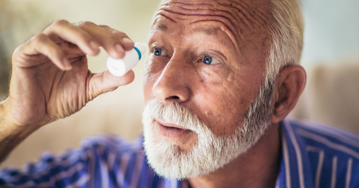 Elderly man with Glaucoma. He is has eye drops in front of his eye.