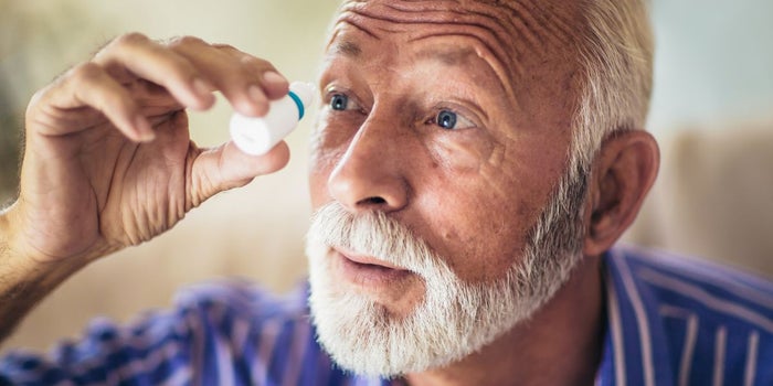 Elderly man with Glaucoma. He is has eye drops in front of his eye.