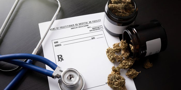 Medical marijuana on top of a report next to medical equipment.