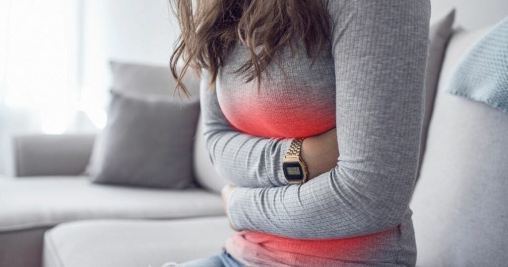 Menstrual cramp causing her to hold her stomach. The affected stomach area is highlighted red.