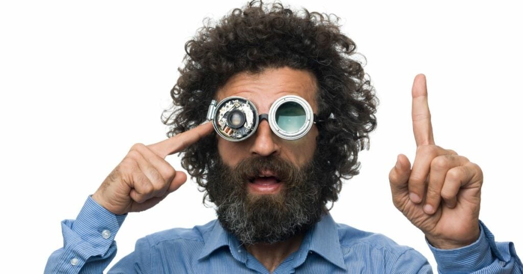 Male scientist with goggles and black curly hair.