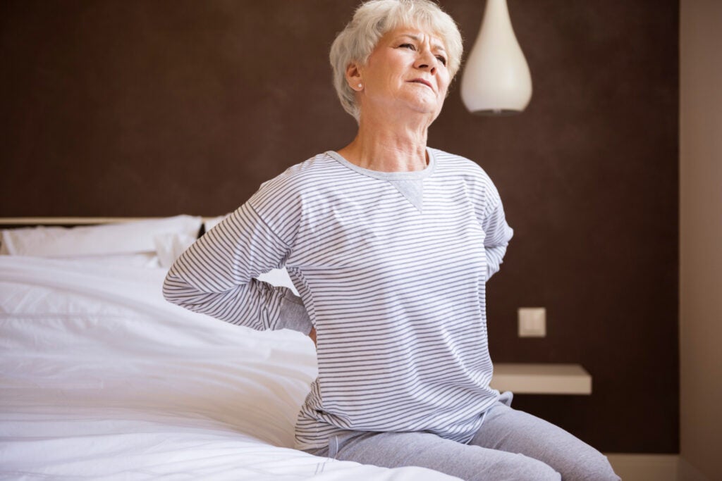 this-bed-isn-t-comfortable-pain-back-elderly woman