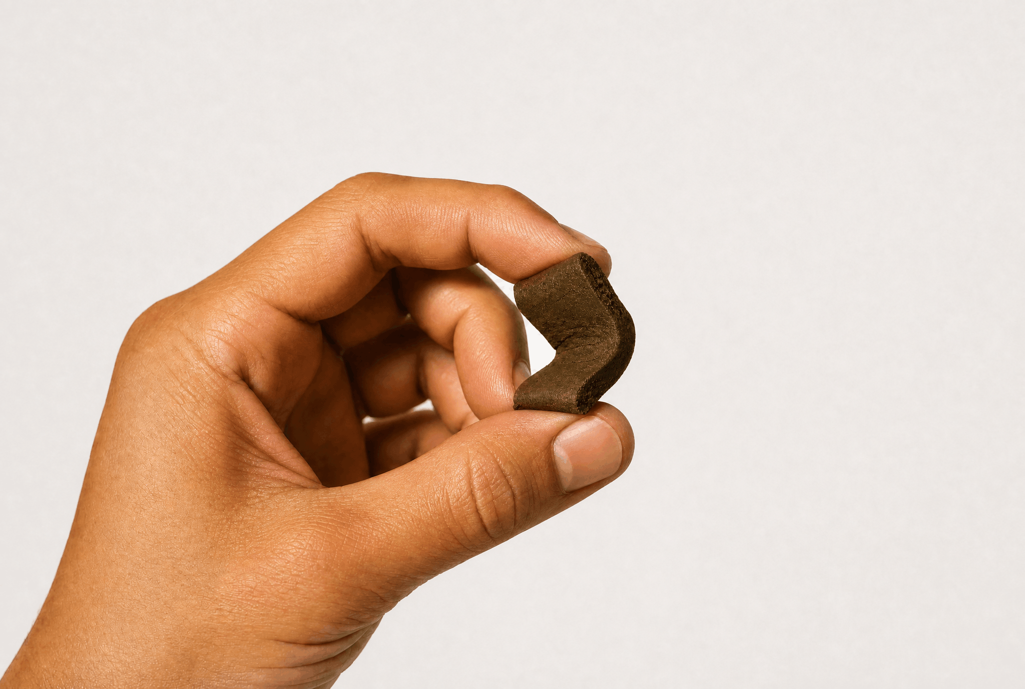 Hand warming a piece of hash to test its texture and pliability for quality