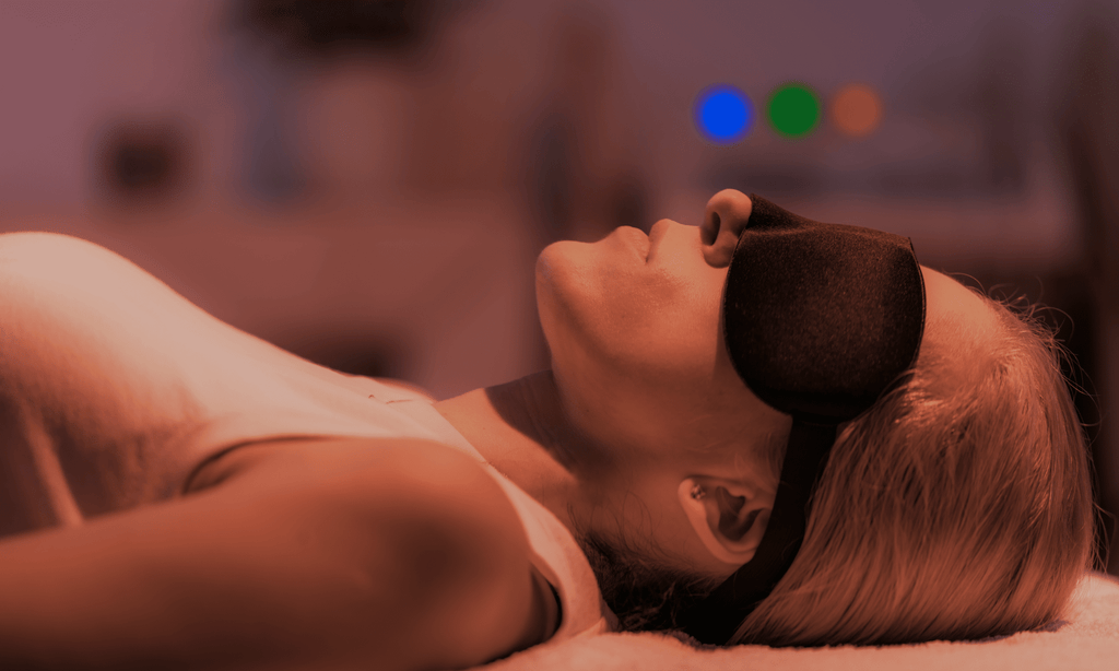 woman lying down with a face mask on having a gentle psychedelic experience