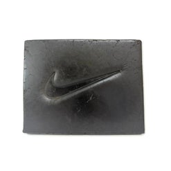 Slab of Hive Nike Hash with a swoosh-style logo embossed into its grey surface, newer photo