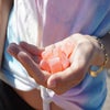 Young woman wearing tie-dye t-shirt holding red thc edibles in her hand.