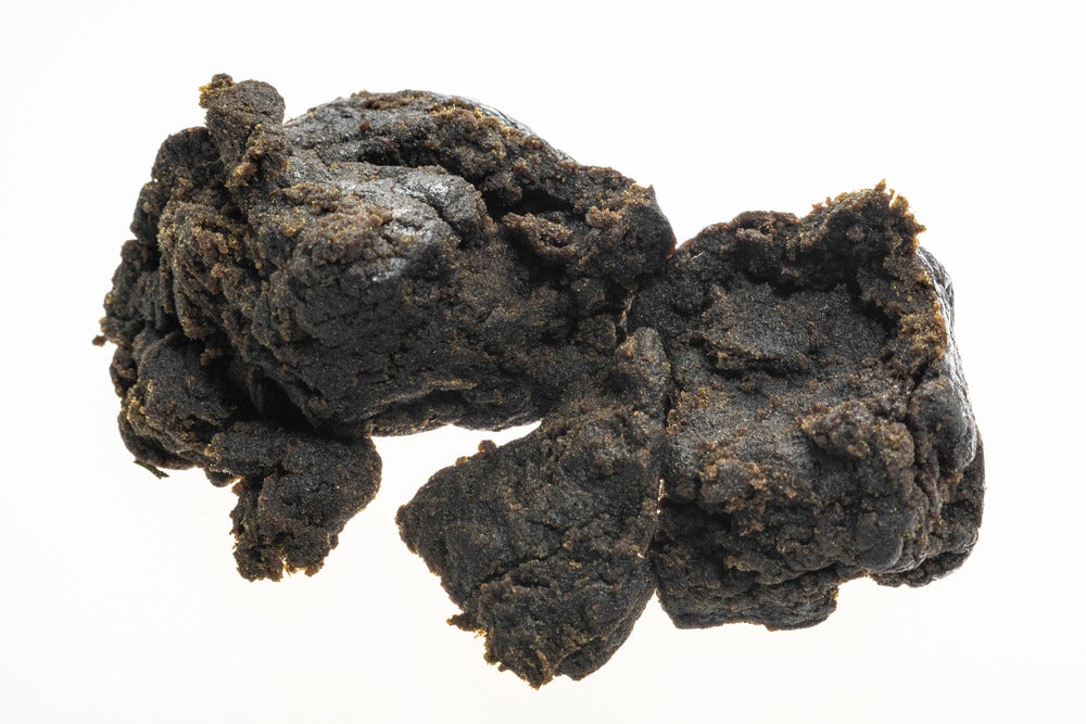 Charas Hashish, black coloured substance on a white background.