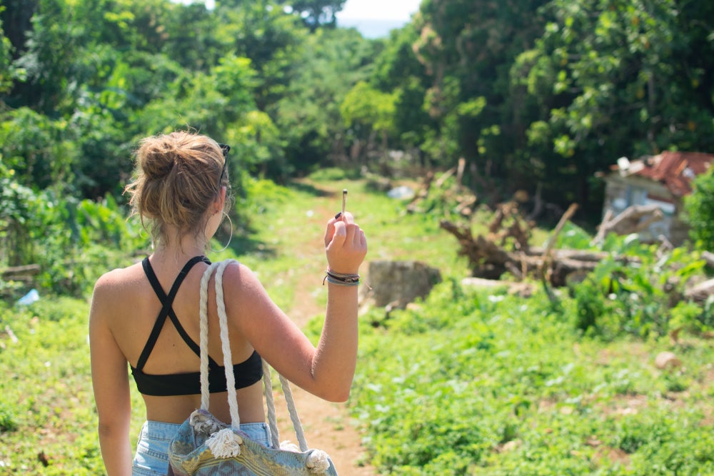 woman holding cannabis joint facing away from camera