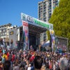 420 event in Vancouver BC. Crowd of people gather around a stage with '420 Vancouver' banner across it.