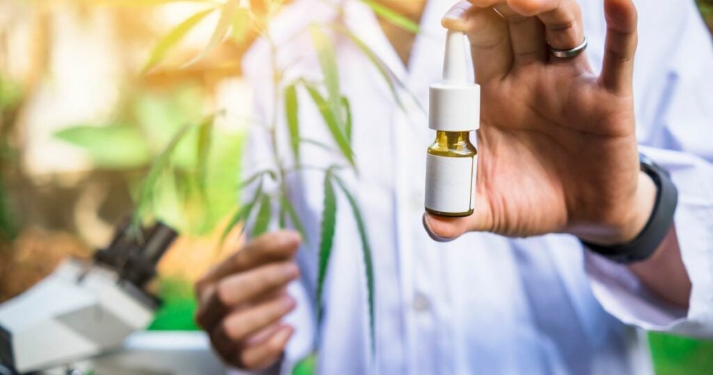 Person holding a bottle of Oil cannabis for ADHD relief - THC - CBD - Pain relief - pain treatment - natural remedy
