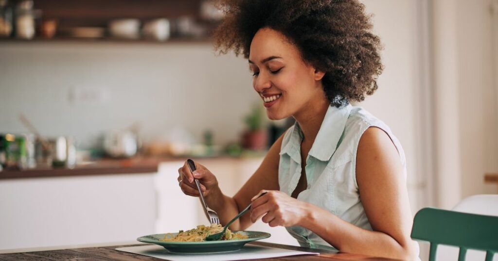 Woman with appetite - woman eating healthy food - pasta
