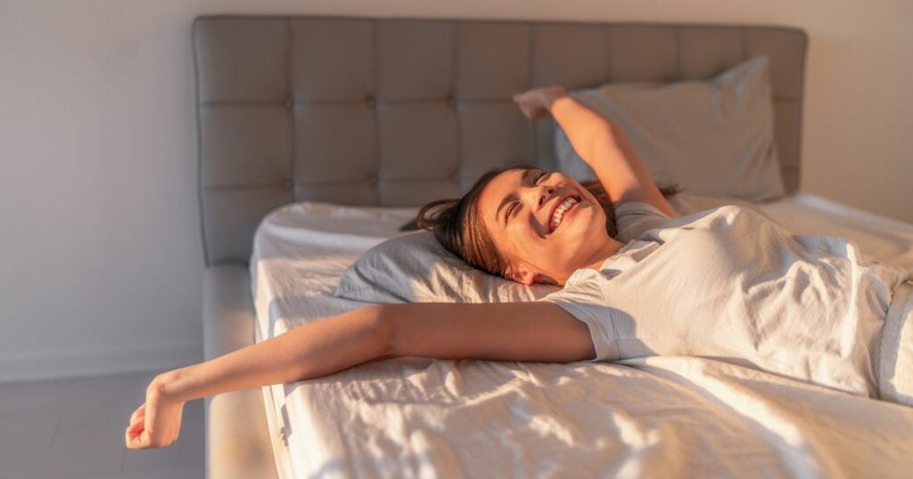 Woman without insomnia - good sleep - relief - in bed - smiling