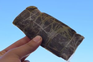100g of moroccan hashish held up proudly with two fingers by a Moroccan citizen