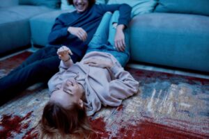 Young couple relaxing next to the sofa while smoking a joint.