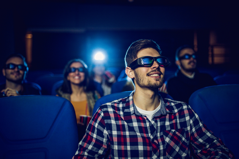 This image features a group of people watching a movie tying into the topic of the best movies to watch high.
