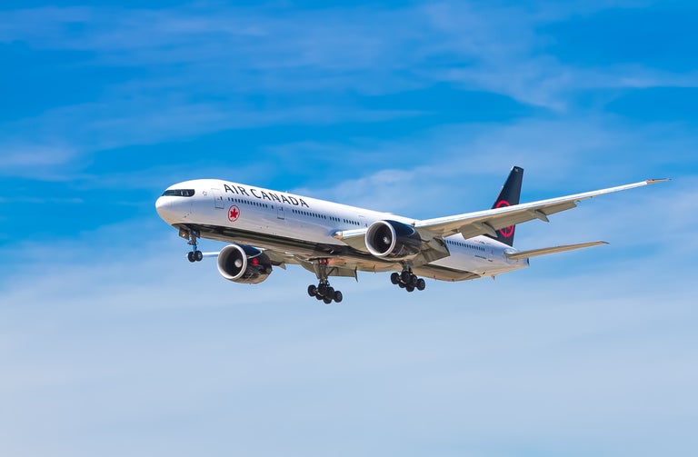 Air Canada flight. Airplane flying in a blue sky with no clouds.