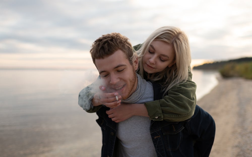 Couple smoking weed on the beach.