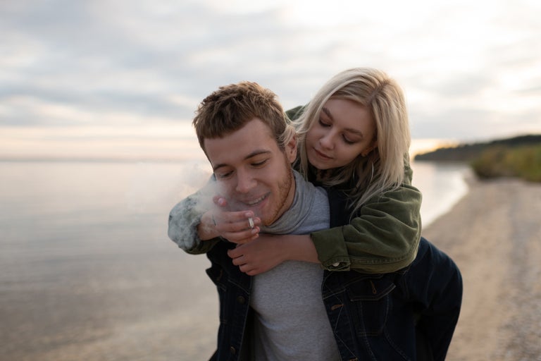 Couple smoking weed on the beach.