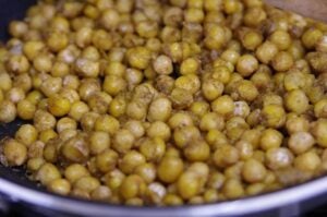 Roasted chickpeas. A bowl full of yellow & small circular vegetables.