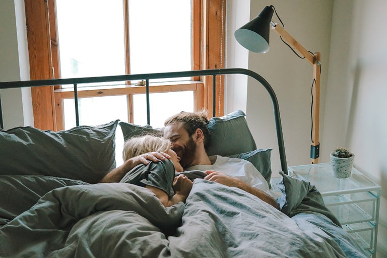 A young couple cuddling in bed