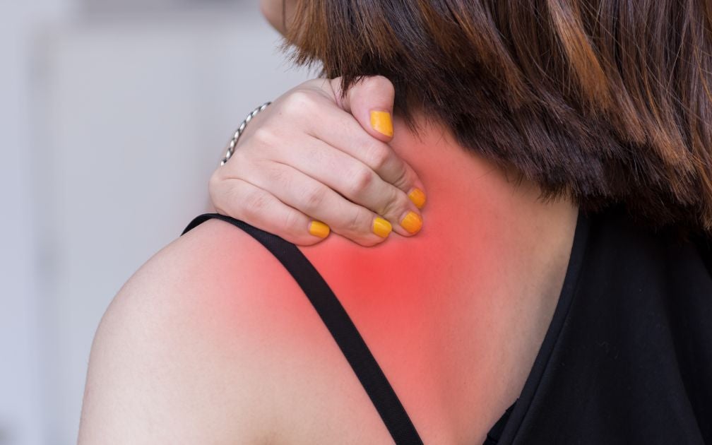 Young female holding her back due to chronic pain.