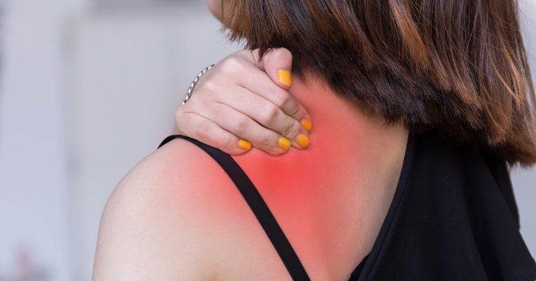 Young female holding her back due to chronic pain.