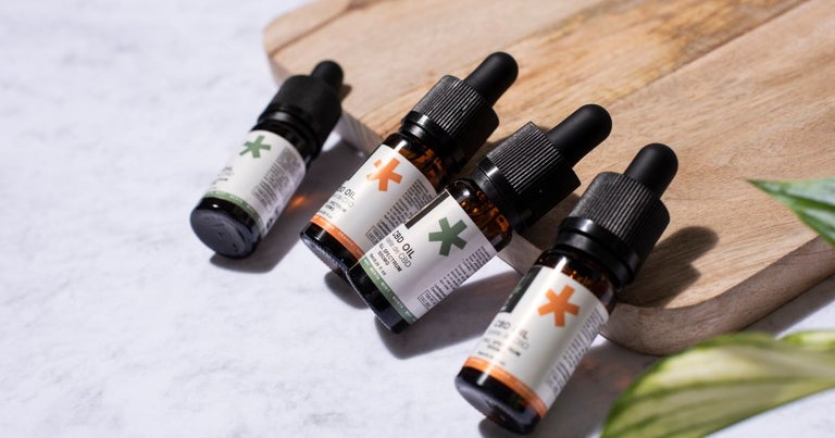 CBD oil products sitting on a wooden board.
