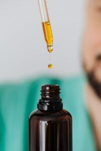 CBD oil in a dark brown bottle. A syringe is used to extract it's contents.