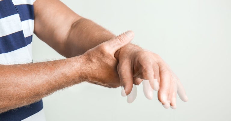 Man - hands with Parkinson - holding his hand shaking