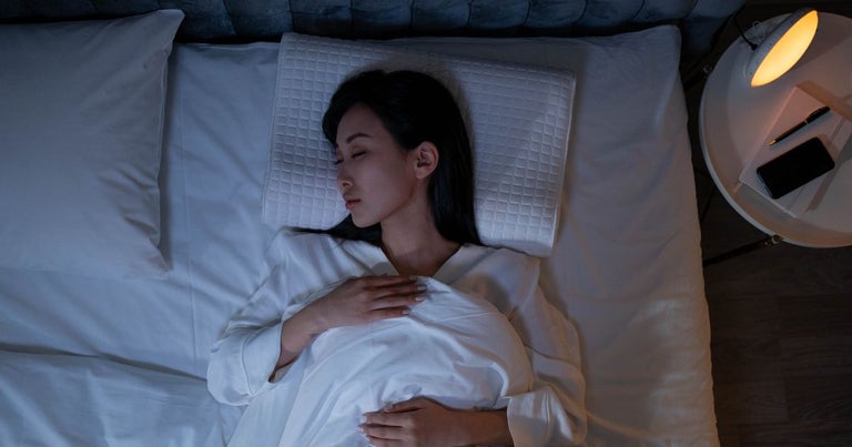 Young asian lady sleeping in a white bed.