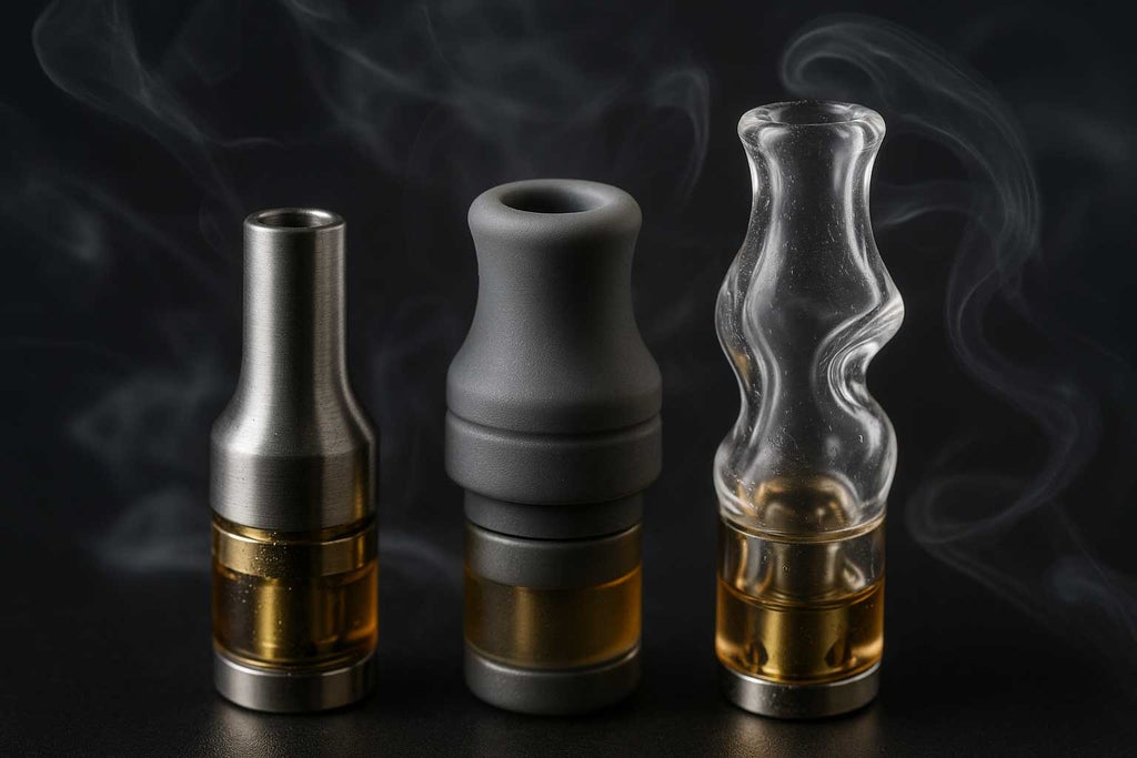 Macro photograph showing three vape mouthpieces metal, silicone, and glass, on a matte black surface, highlighting their textures, condensation, and vapour wisps. Designed to showcase airflow options and material differences for cannabis vaping.
